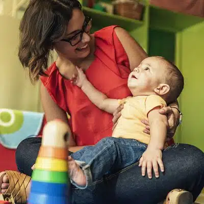 Teacher with an infant in her lap